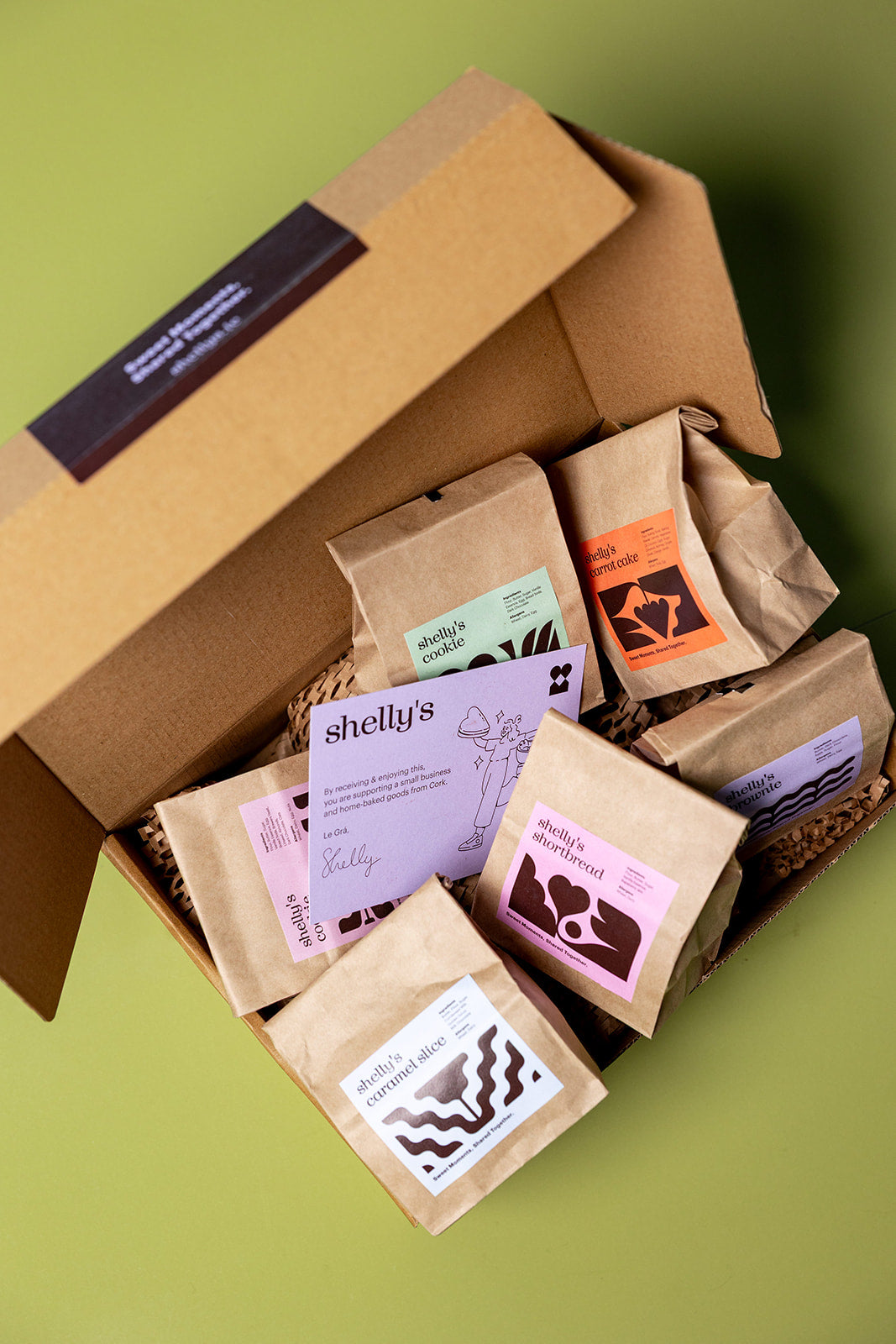 An open Shelly's treat box with labelled treat bags and a card signed Le Grá, Shelly
