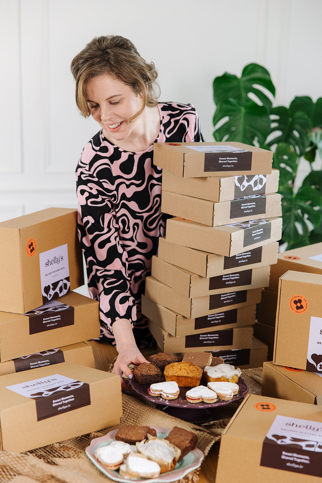 Shelly arranging freshly baked treats beside her gift boxes